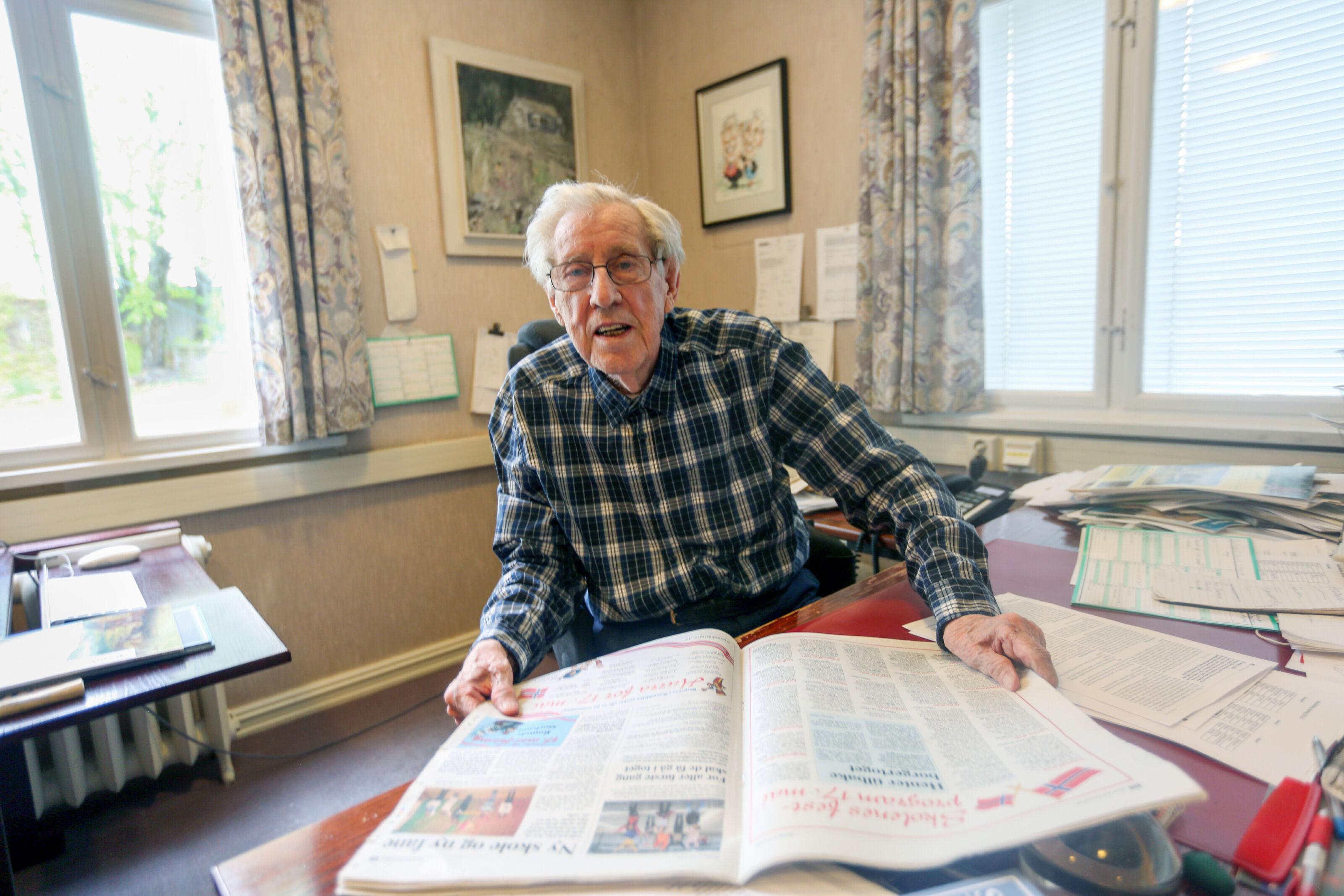 Hjalmar Kielland på sitt kontor i avishuset på Grorud. På veggen bak ham henger det synlige beviset på hedersprisen som han og kona Margit mottok av Landslaget for lokalaviser i 2007 - under landsmøtet på Lillehammer. Foto: Rolf E. Wulff