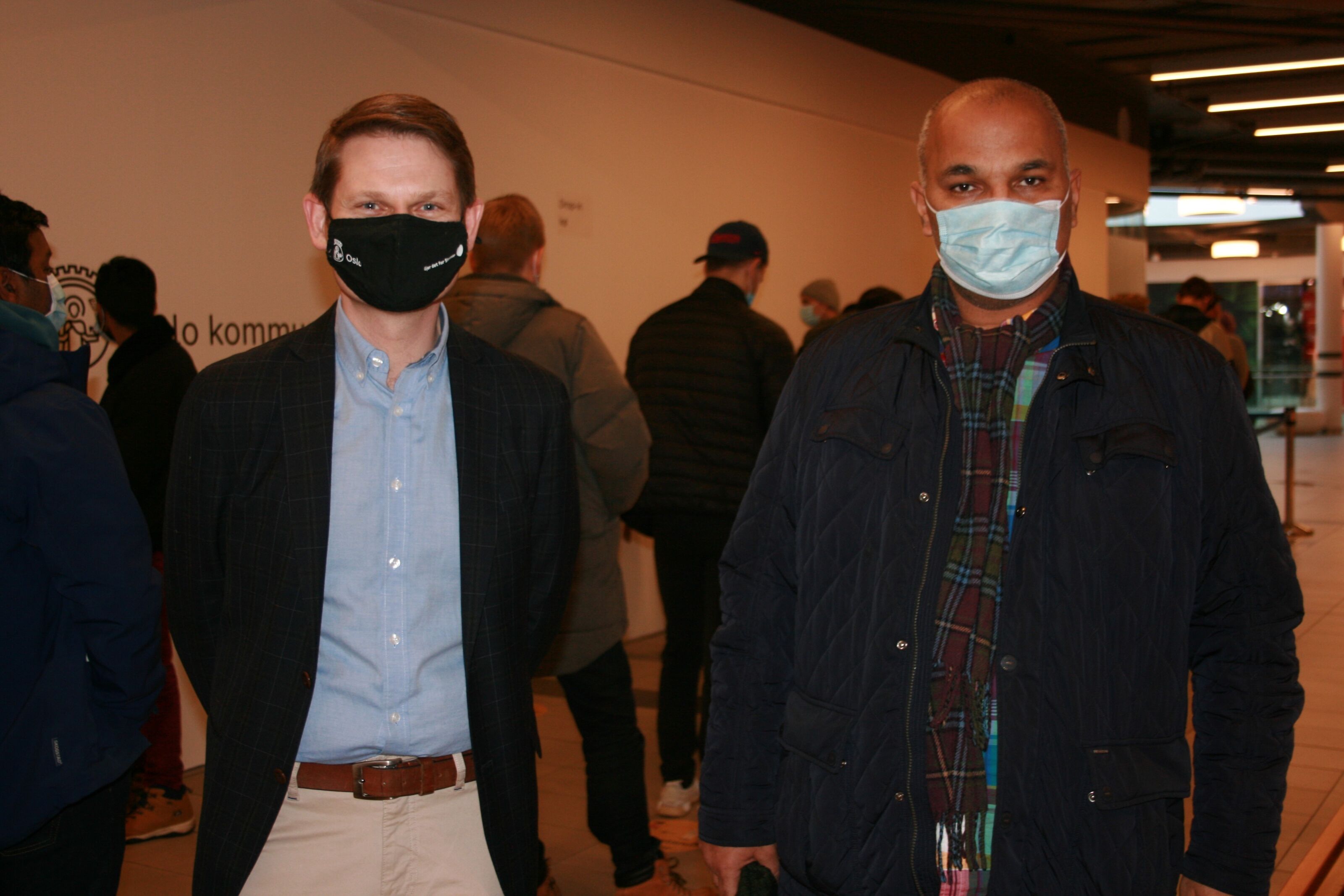 LANG KØ: Assisterende bydelsdirektør Andreas Behring (t.v.) og BU-leder Rashid Nawaz (Ap) kunne glede seg over at mange tok muligheten til å få enten første, andre eller tredje dose av koronavaksinen torsdag. Da åpnet man for at også de utenfor Bydel Stovner kunne få vaksine hos dem. Foto: Caroline Hammer