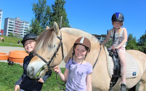 PÅ FESTIVAL: Vilde (8, f.v) og Kristina (9) fra Alna rideskole leier hesten som Hanna (7) rir på. De storkoser seg på Furusetfestivalen. Foto: