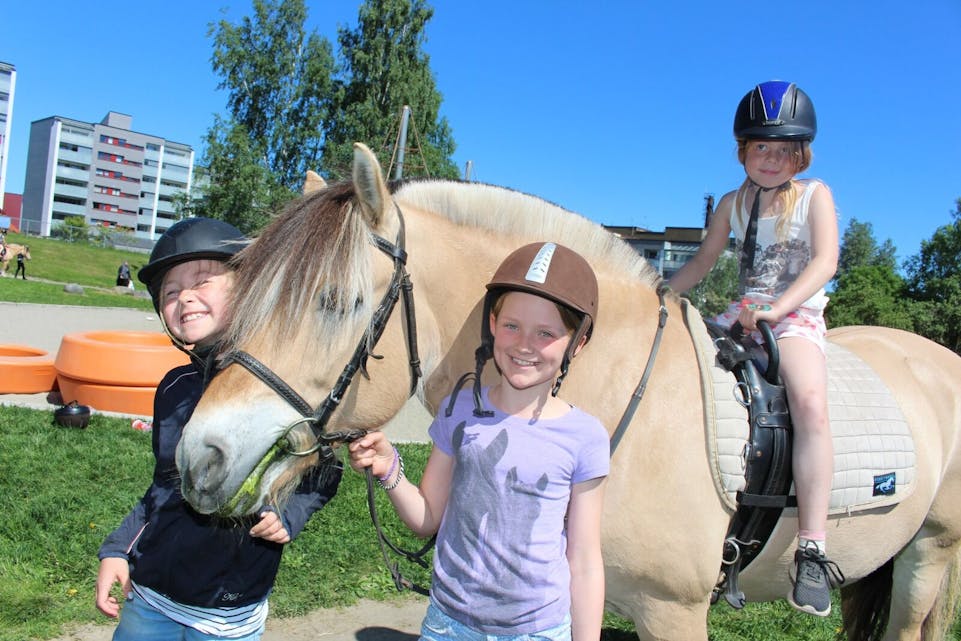 PÅ FESTIVAL: Vilde (8, f.v) og Kristina (9) fra Alna rideskole leier hesten som Hanna (7) rir på. De storkoser seg på Furusetfestivalen. Foto: