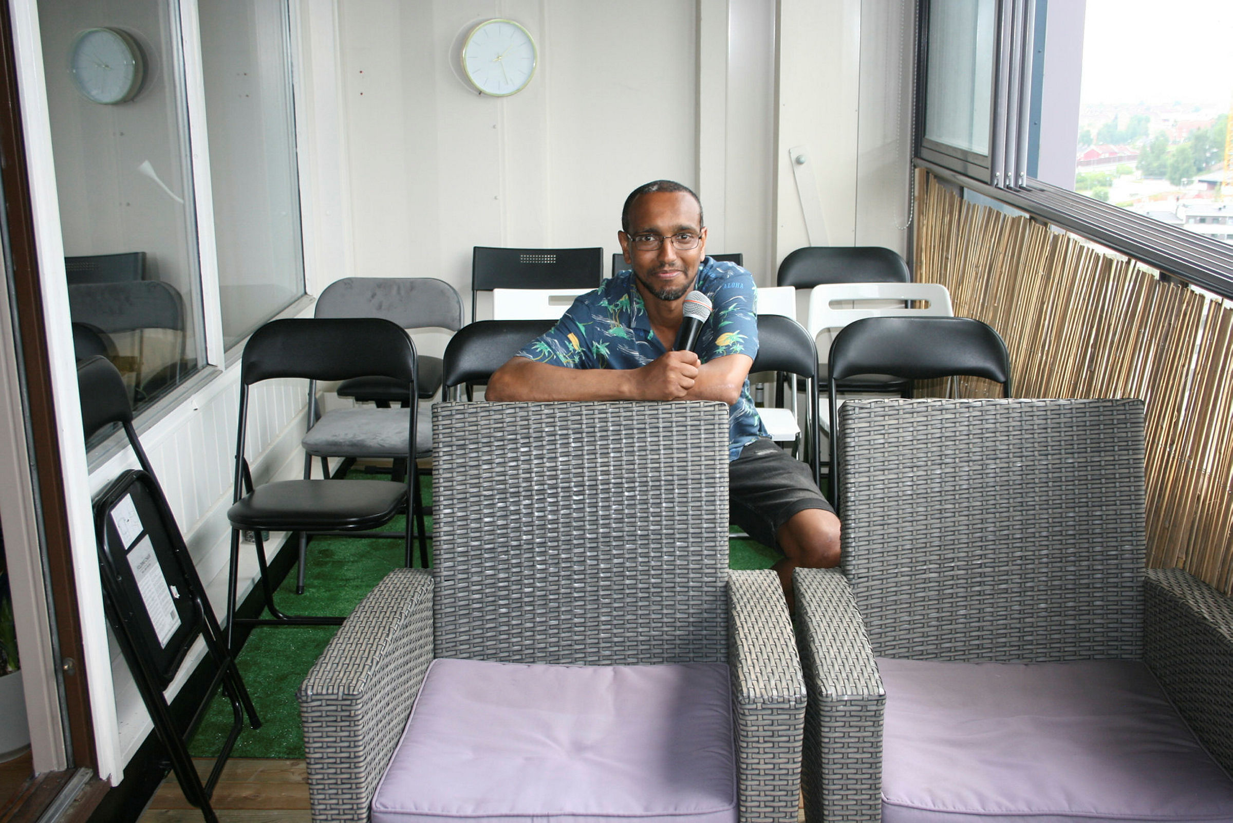 INTIMT OG PERSONLIG: Liban Gulaid viser fram både seg selv og egen leilighet. Her er det altså ikke snakk om at han skal tale ned fra balkongen til folk på gresset utenfor. Alle skal opp på balkongen. Foto: Caroline Hammer