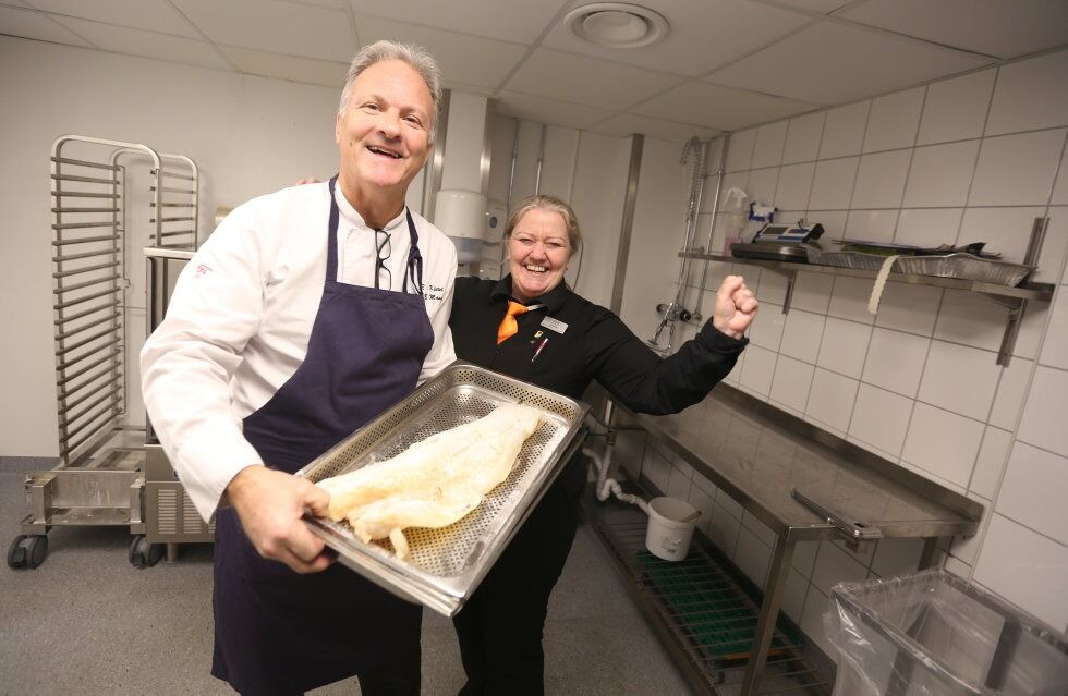 LUTEFISK: Mesterkokk og daglig leder Reinhard Küttel og restaurantsjef Grethe Kornstad med prøvelutefisk fra Laks- & Vildtcentralen. Bare ved å se på den kan de med brede smil konstatere at det som vanlig er lutefisk av ypperste kvalitet. Men ingenting overlates til tilfeldighetene. Her skal hver minste detalj sjekkes - for kun det beste er godt nok for Groruddalen Matklubb og dens lutefisktilhengere. Foto: