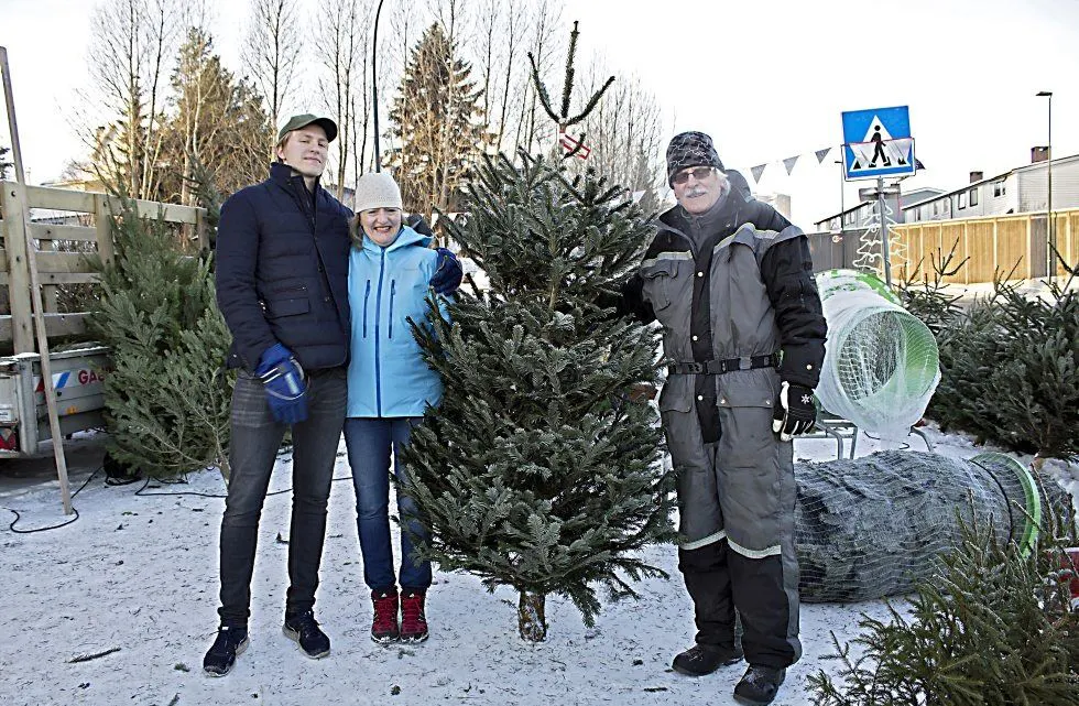 JUBILEUM: Knut Bjørnstad (til høyre) har solgt juletrær i 40 år. Astrid Dahl og sønnen Max har handlet juletrær hos ham siden siden Max var liten. Foto: