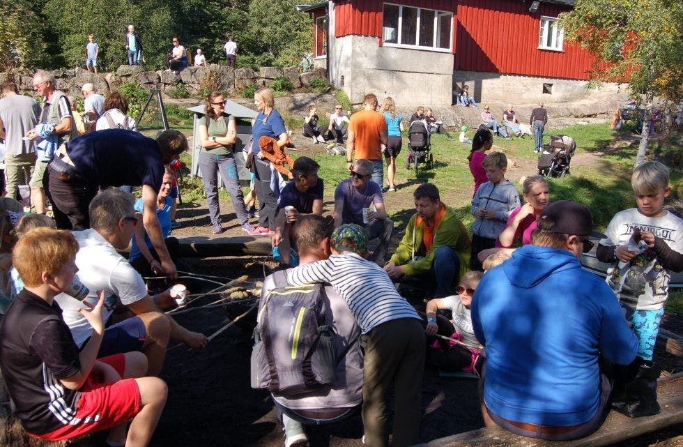 BÅLKOS: Flere familier hadde samlet seg rundt bålet for grilling av pølser og «pinnebrød». Heldigvis kom regnet i tide til å redde den utendørs grillingen. Foto: