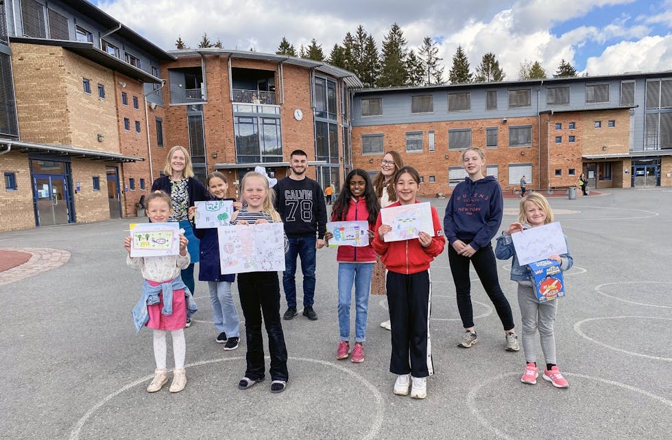 DRØMMESKOLEGÅRDEN: Her er vinnerne i tegnekonkurransen som ble gjennomført ved Ammerud skole for å finne fram til elevenes drømmeskolegård. Foran fra venstre ser vi Adea, Vilde, Sarah og Alma Kristin. I midten: Milda og Agshana. Bak fra venstre er FAU-leder Meyla Sylvestog Enerly, miljøterapeut Arben Fetishi, sosialarbeider Therese Bygjordet Berge og elevrådsleder Uma Enerly. Foto: