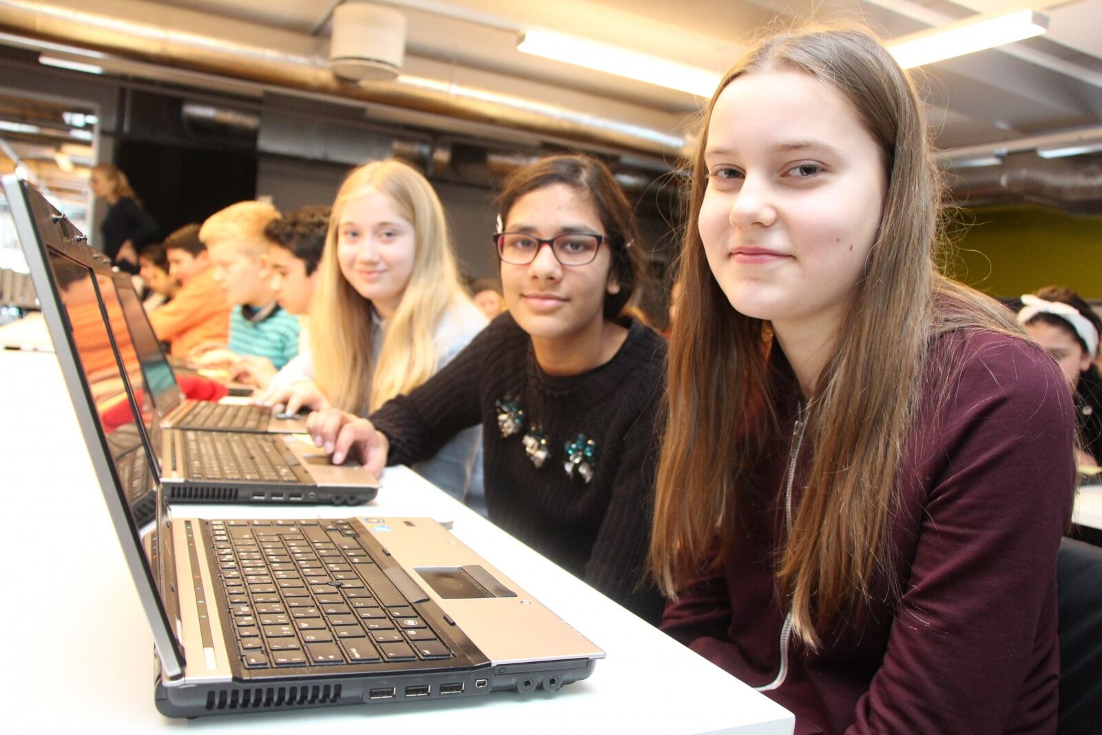 TRYGGE PÅ NETT: Vanessa (t.h), Labya og Elise er alle 12 år og går i 6. klasse på Lindeberg skole. De fikk lære seg nettvett og koding av Microsoft og LIN (likestilling, inkludering og nettverk) på Furuset bibliotek og aktivitetshus under «Safer Internet Day».  Foto: