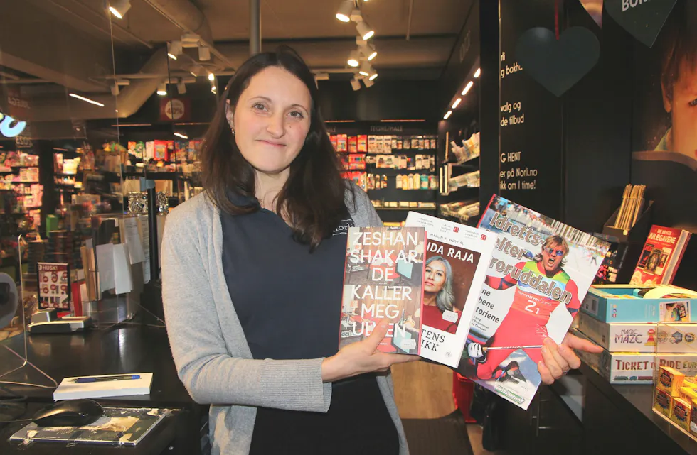 GULLPLASS: Idrettsutøvere fra Groruddalen har sanket gullmedaljer både i skisporet og på isen, og nå gjør boka om idrettsprofilene våre det samme. Her med butikksjef Janette Circhirillo. Foto: Sindre Veum Apneseth