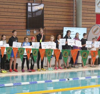 PÅ RAD OG REKKE: Under åpningsseremonien på fredag hadde alle lagene en svømmer som representerte sin klubb. Foto: