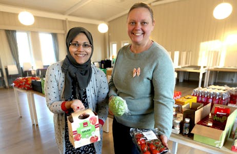 Attia Mirza Mehmood og Anne-Beth Grihamar viser frem noen av matproduktene de leverte ut på menighetshuset ved Østre Aker kirke. Foto: Rolf E. Wulff