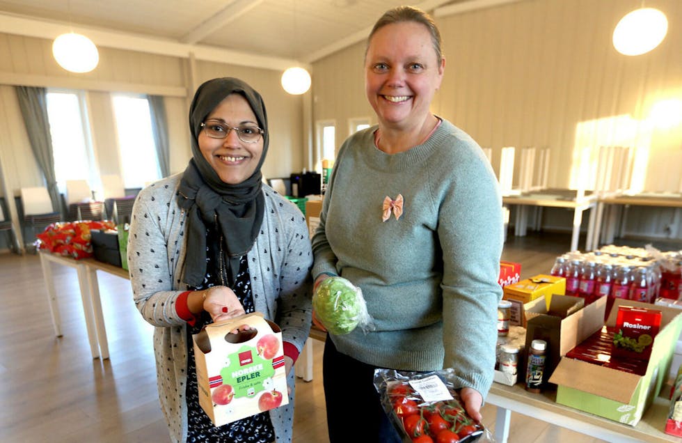 Attia Mirza Mehmood og Anne-Beth Grihamar viser frem noen av matproduktene de leverte ut på menighetshuset ved Østre Aker kirke. Foto: Rolf E. Wulff