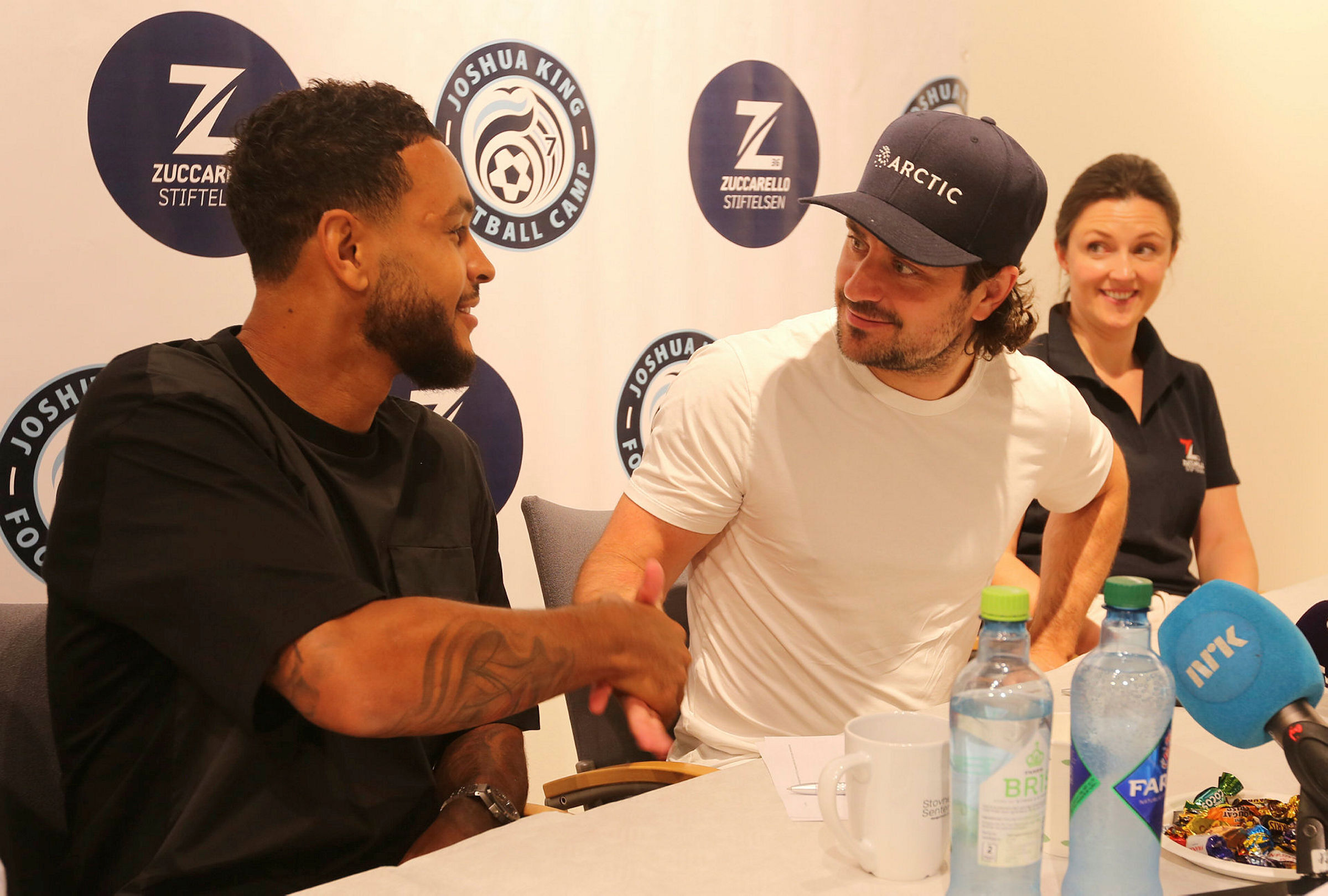 VIKTIG HÅNDTRYKK:Joshua King og Mats «Zucca» Zuccarello tar hverandre i hendene. Nå skal de to store idrettsprofilene fra dalen samarbeide med å gi gratis fotballtilbud til barn og unge. De har sett seg lei på at mange unge blir stående på sidelinja fordi foreldrene ikke har råd til å sende dem på fotballskoler og andre idrettslige aktiviteter.