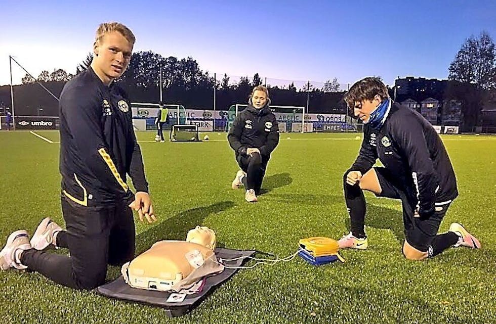 TEST: Grorud-spillerne Geirald Meyer og Vetle Skåttun testet ut klubbens nye hjertestarter sammen med lederen for barnefotballen i klubben, Vilde Mollestad Rislaa. Foto: