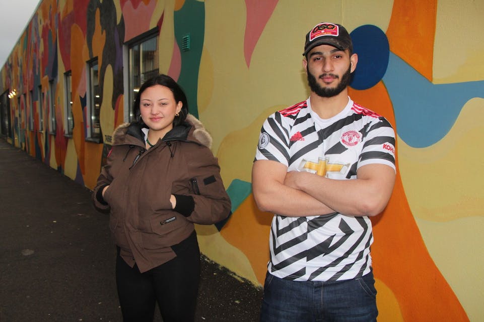 FÅR JOBBEN GJORT: Mita (t.v) og Taibbie er to av ungdommene som har vært med på å male veggen. Foto: