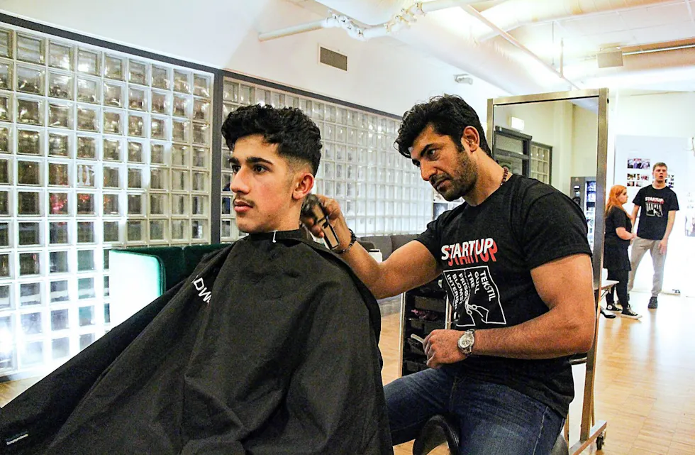 POPULÆRT: Elvebakken videregående skole er en av Oslos mest populære skoler, og jobber iherdig for å nettopp være det. Nytt fra og med neste år av er Frisør, blomsterdekoratør, interiør og eksponeringsdesignfaget. Her med Amir Ali Chegeni og frisør Wisam Amer. Foto: