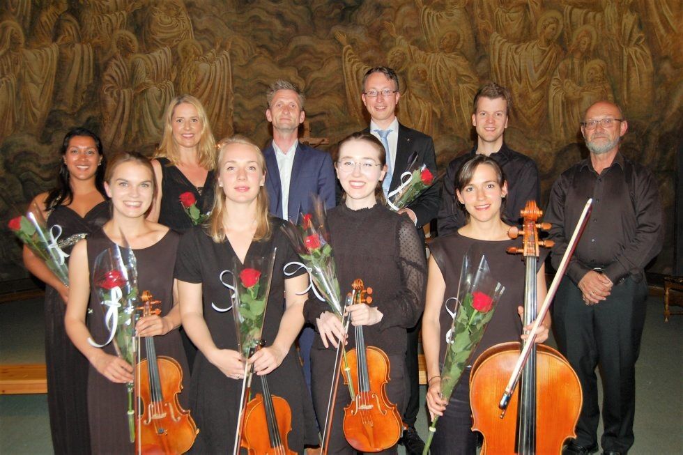 SOLISTER OG MUSIKERE: Foran fra venstre står Madelene Berg, fiolin, Guro Saastad, bratsj, Victorie Putterman, fiolin og Paula Cuesta, cello. Bak fra venstre står Marilyn Almeida, sopram, Silje Vatne Heggem, alt, Gjermund Brenne, dirigent, Haakon Hille Hustad, bass, Øystein Stensheim, tenor og Terje Winge, orgel og kororgel. Foto:
