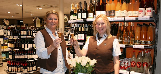 25 ÅR: Siv Anine Moen (t.v.) og butikksjef Aud Søyland har jobbet i Vinmonopolet i 25 år hver. Nå skåler de for arbeidsplassen, som har holdt det gående i 100. Foto: Caroline Hammer