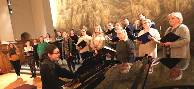 GLEDER SEG: Rådhuskoret med dirigent Bjørn Hegstad ser fram til å synge i Grorud kirke førstkommende lørdag. De ble imponert over akustikken i kirka da de øvde før konserten. Foto: