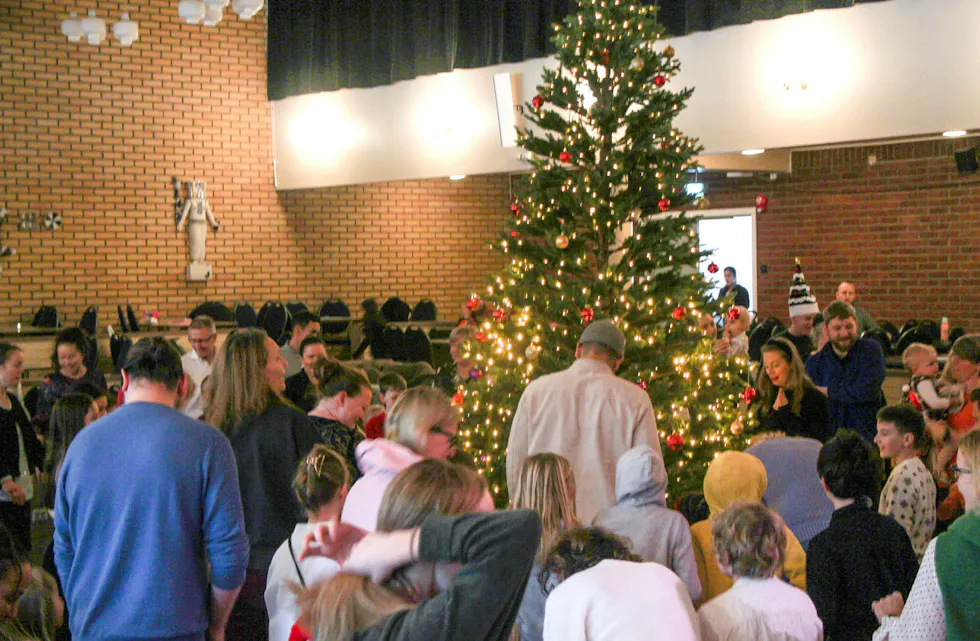 260 naboer møttes til juletrefest på samfunnshuset. Festen startet med sang rundt juletreet. Foto: Mina Wathne