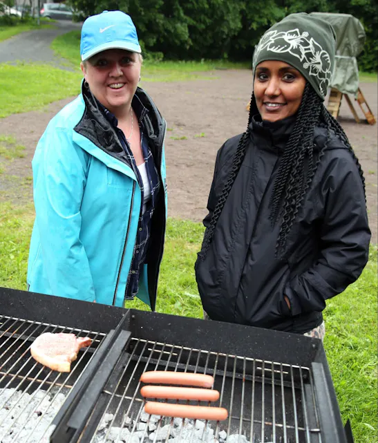 PÅ GRILLEN: Anne-Line Hessen (tv) og Kolish Bekele brydde seg ikke om det kom noen dråper på grillmaten - det smakte godt likevel. Foto: