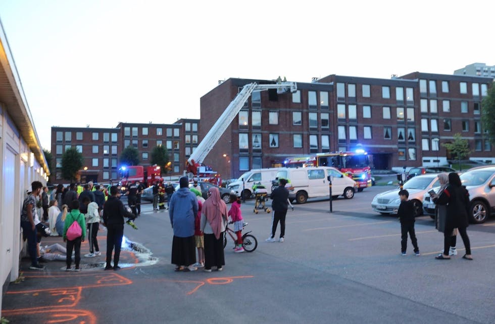 BLE EVAKUERT:Alle som bor i de 24 leilighetene i blokka hvor det begynte å brenne i 4. etasje i Linderudveien 7 ble evakuert og foreløpig plassert på parkeringsplassen ved blokka. Foto: Rolf E. Wulff