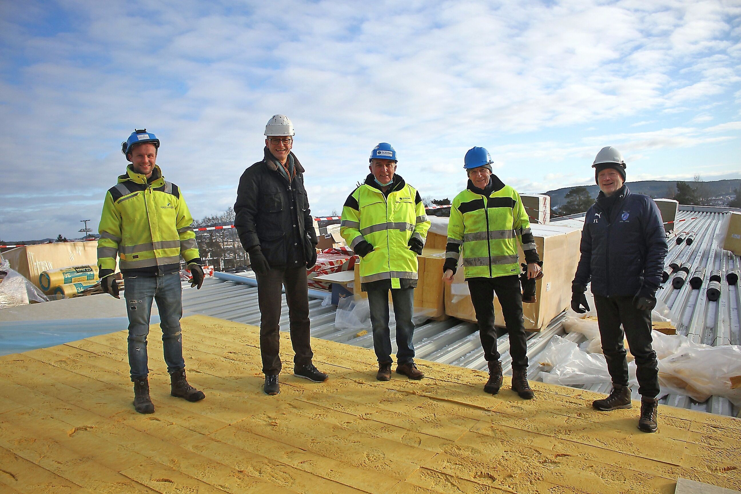 PÅ TOPPEN: Grei-delegasjonen med Asgeir Moripen, Harry Bjørnevik, Bjørn Haug og Tom Løw fikk lov å komme opp på taket til den nye hallen for å ta en titt. Kvartetten er svært glade for at arbeidet nå går fort unna. Til venstre står Knut Olav Haugen fra Hallmaker. Foto: