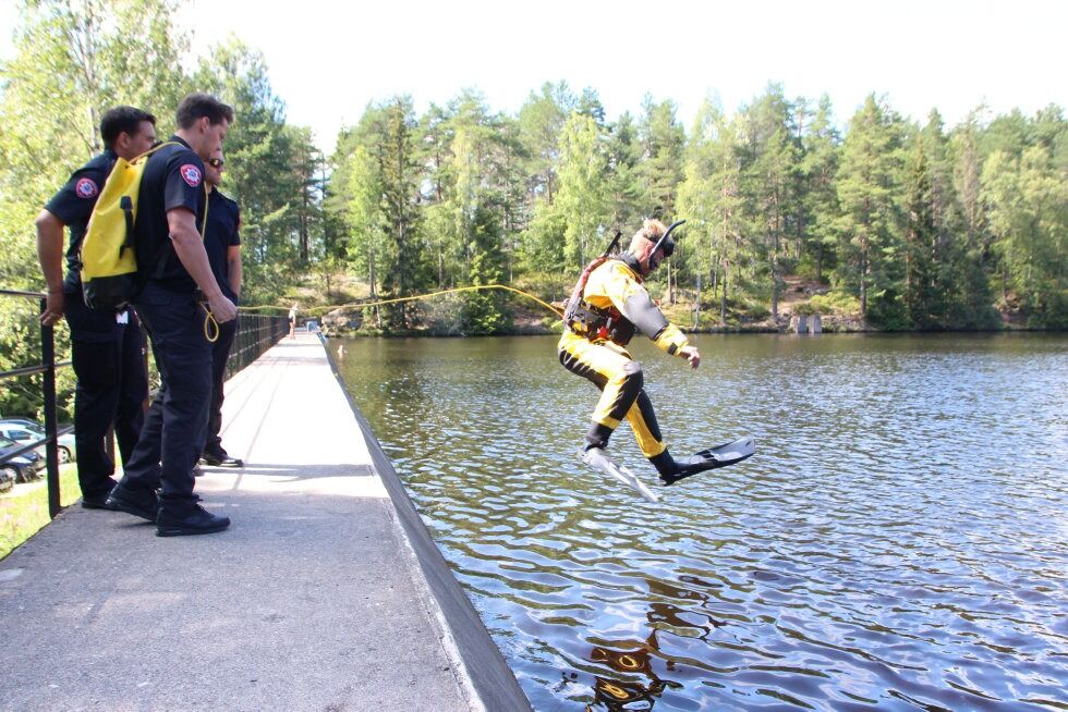 SAMARBEIDER: Glenn Edvardsen hiver seg ut i vannet ikledd våtdrakt og fullt redningsutstyr. På land følger kolleger med og holder i lira som er knytet rundt Edvardsens liv. Foto: