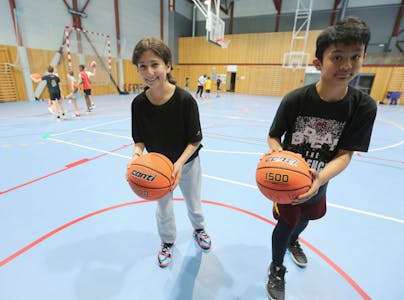 KOSER SEG:Helin (12) (t v) og Froilan (12) stortrives på basketcampen i Apaløkka idrettshall. De lærer mye nytt og får mange nye venner. Dessuten er de fornøyde med at trenerne er både snille og strenge. Foto: Rolf E. Wulff
