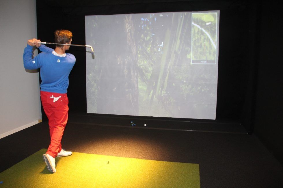 NYTT TILSKUDD: Hovedtrener Per Falk tester ut en av de to nye golfsimulatorene. Foto: