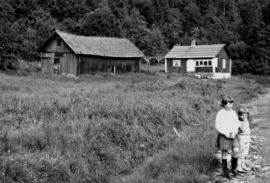Bildet viser våningshuset på Enga med innebygget glassveranda og den gamle låven. Bildet er tatt i 1962-1963. Foto: Gunnar Søderstrøm.