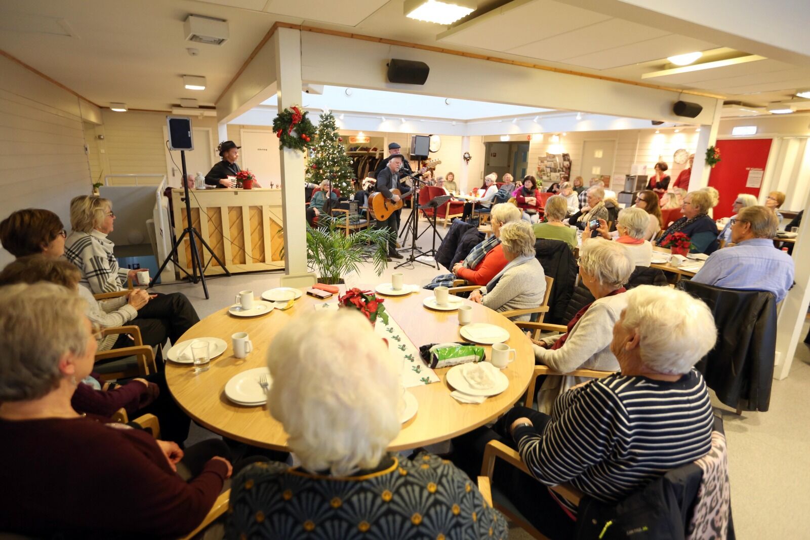 MANGE TILHØRERE: Her ser vi kun litt av det koselige lokalet til Haugerud seniorsenter. Men det satt tett i tett med publikum over det hele. Trond Granlund ville de ha med seg! Foto: