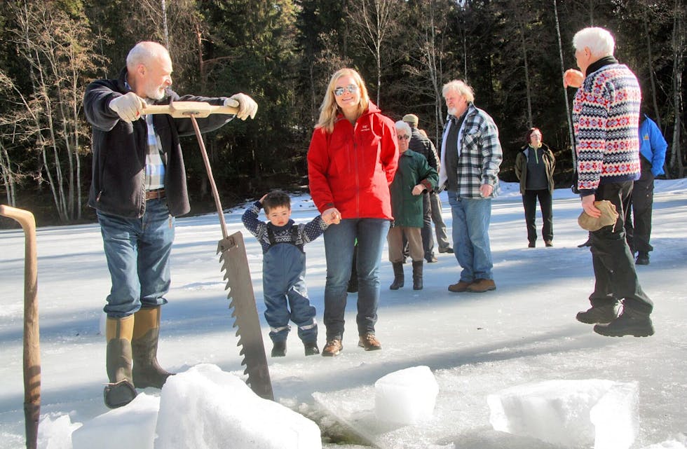 DEMONSTRERER: Ragnar Høvik skjærer ut isblokker på vinteraktivitetsdagen ved Øvre Isdam på søndag. Her fra en tidligere markering hvor Erling (3) og mamma Astrid Kleiveland Unander følger nøye med. Foto: