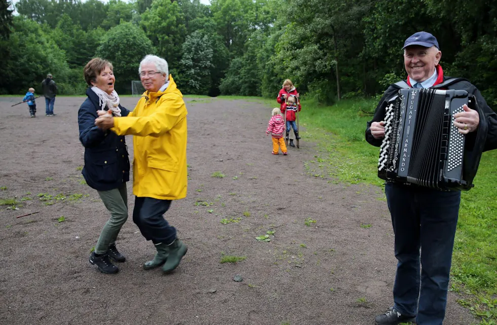 TREKKSPILLDANS OG STYLTER: Mens de minste prøvde seg på stylter, sørget Erling Heen for trekkspillmusikk. Og da ble kona Solveig bydd opp til dans av Arve Hoff. Foto: