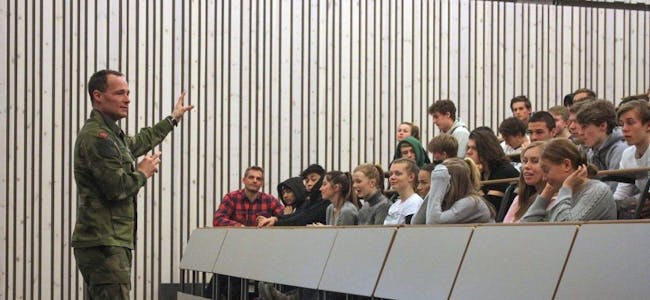 NÅDDE FRAM: Major Eldar Frøland sammen med Bjerke-elevene i auditoriet på Krigsskolen. Kaja Hamang, første rad med hvit genser, gir besøket tommel opp. Foto: