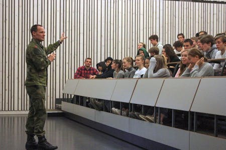NÅDDE FRAM: Major Eldar Frøland sammen med Bjerke-elevene i auditoriet på Krigsskolen. Kaja Hamang, første rad med hvit genser, gir besøket tommel opp. Foto: