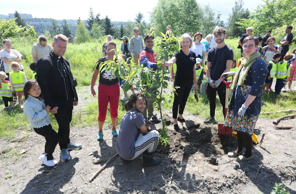 PÅ PLASS:Endelig sto det første frukttreet i jorda i Ulven nærmiljøhage. Prost i Groruddalen Prosti, Øyvind Stabrun (f v), menighetsrådgiver Eli Solberg, sokneprest Anne Berit Evang, prest Sara Moss-Fongen, samt Amir og Mustafa fra de arbeidende ungdommene gleder seg over resultatet. Foto:
