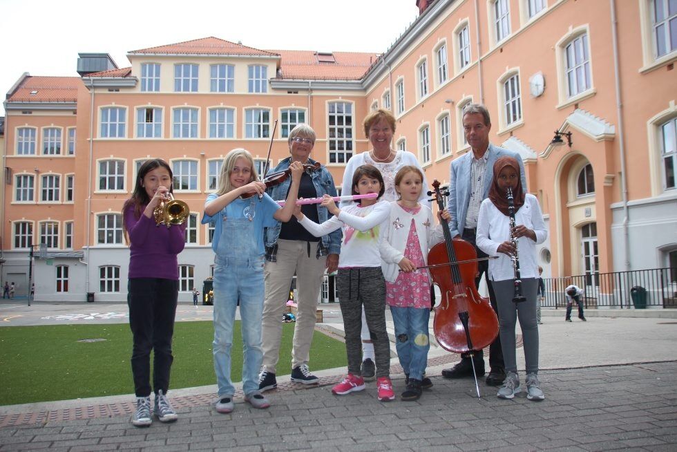 TETT SAMARBEID: Ordfører Marianne Borgen smiler når hun hører om Tøyens aktivitetsskole. Her står hun sammen med Sissel Larsen fra Kulturskolen (bak til venstre) og rektor Terje Andersen på Tøyen skole. Foran står elevene Jin Lykke (9), Linnea (8), Lina (9), Agnes (9) og Miski (9). Foto: