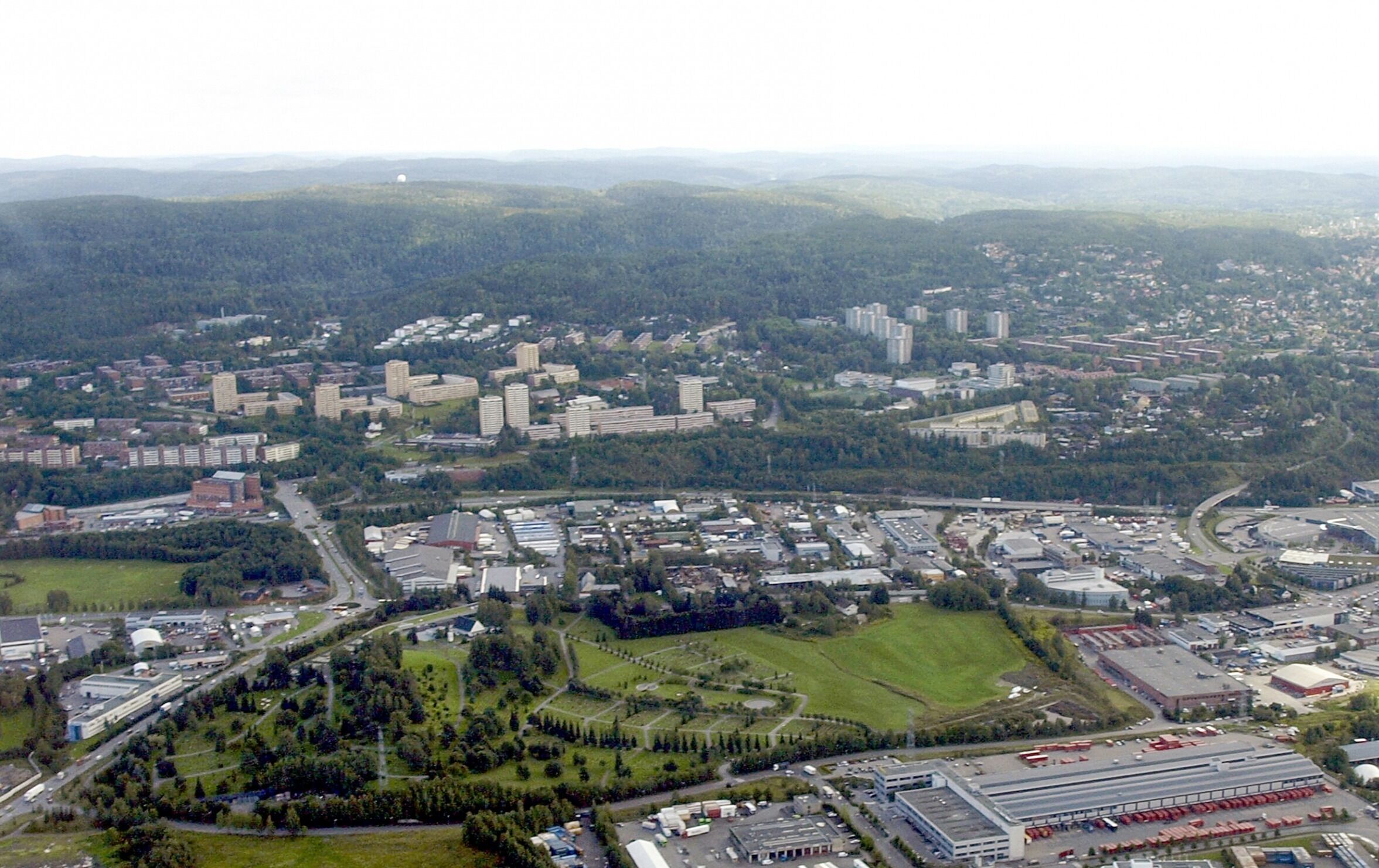 Trosterud er de gule høy- og lavblokkene til venstre. Stubberud er industrifeltet i midten på bildet, langs E6. Foto: