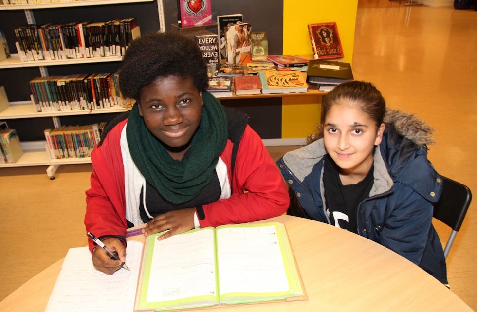 GLEDER SEG: Farida (12) og Muazmah (13) fra Stovner går på Rommen skole, og gjør alltid leksene sine på biblioteket. Nå gleder de seg til leksehjelp. Foto: