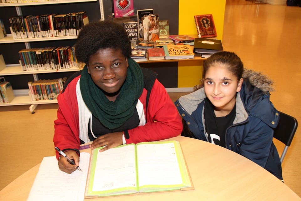 GLEDER SEG: Farida (12) og Muazmah (13) fra Stovner går på Rommen skole, og gjør alltid leksene sine på biblioteket. Nå gleder de seg til leksehjelp. Foto: