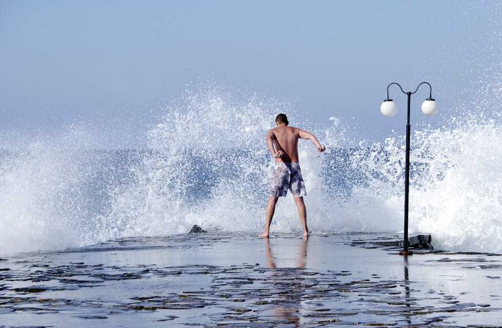OVERRASKENDE: Denne mannen var ikke klar over hvor høyt bølgene kan sprute ved en molo i Hersonissos på Kreta. Øyeblikket ble fanget av Margret Lenschow Ofrim. Foto: