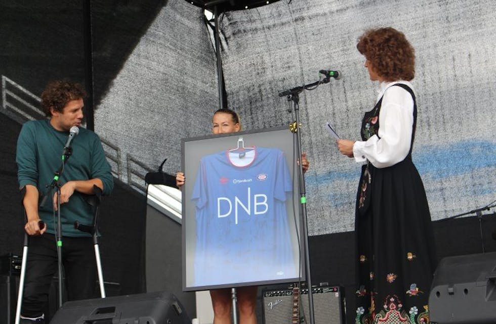 LITEN OVERRASKELSE: Motivasjonstalerne Freddy Dos Santos og Theresa Nielsen overrakte en signert VIF-drakt til rektor Trine Øiseth. Foto: