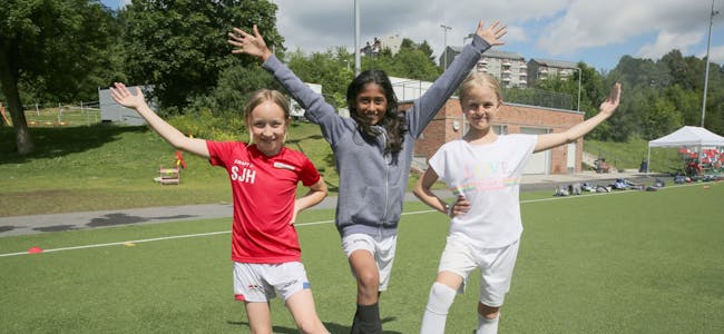 FORNØYDE FOTBALLJENTER: Silje (9, f.v.), Punnya (9) og Astrid (10) storkoser seg på fotballskolen i regi av Årvoll IL. De mener at de er blitt bedre fotballspillere og i tillegg har de det mye moro og treffer nye venner. Foto: