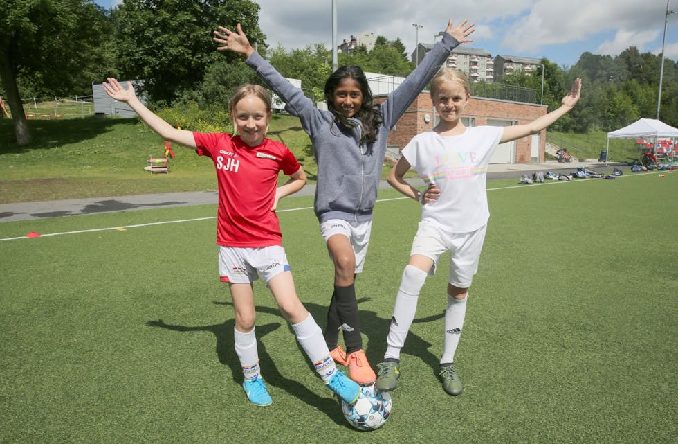 FORNØYDE FOTBALLJENTER: Silje (9, f.v.), Punnya (9) og Astrid (10) storkoser seg på fotballskolen i regi av Årvoll IL. De mener at de er blitt bedre fotballspillere og i tillegg har de det mye moro og treffer nye venner. Foto: