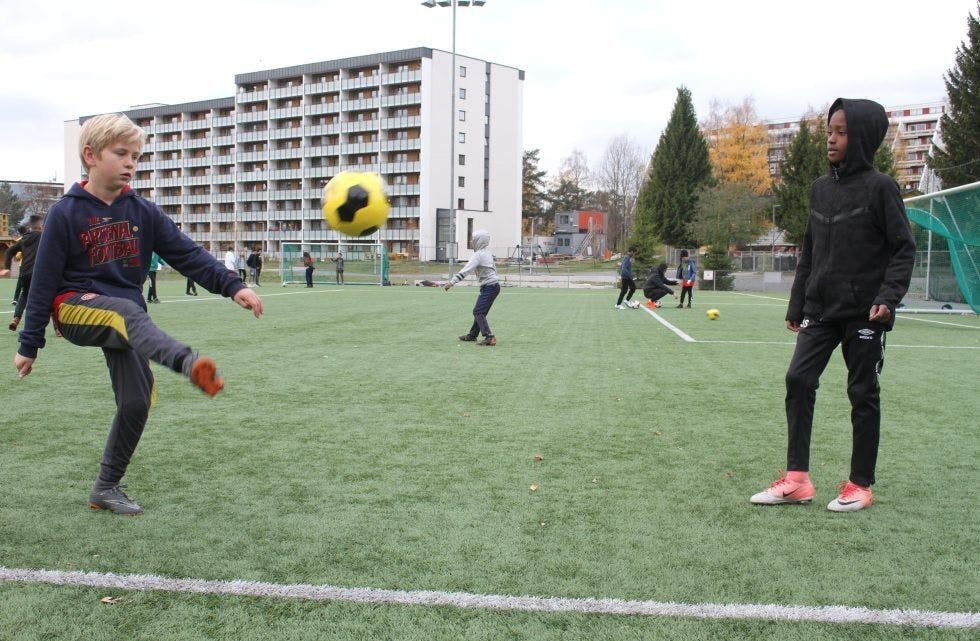 MIDT I BLINKEN: Andreas (venstre) og Seikou spiller fotball på Jesperudjordet. På akademiet til Vestli får barna mat, aktiviteter og læring. Sånn som på AKS, men på Vestli er det enda mer idrett, og det passer fotball-guttene godt. Foto: