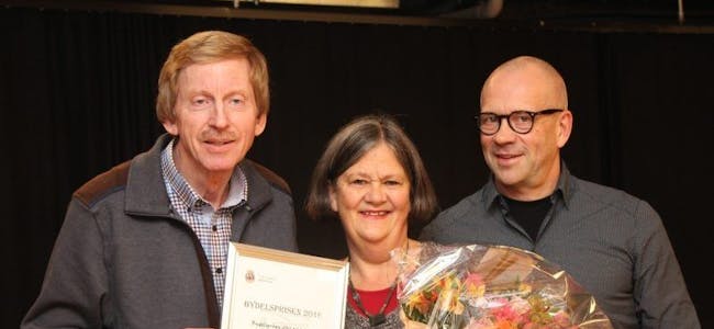 OVERRASKET: Anne Grete Orlien fikk Alna bydelspris 2016 av BU-leder Knut Røli (Ap) og leder Ivar Morken av Alnas oppvekst- og kulturkomité (OKK). Foto: