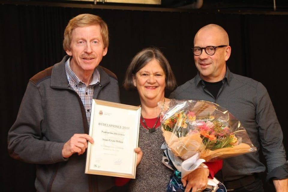 OVERRASKET: Anne Grete Orlien fikk Alna bydelspris 2016 av BU-leder Knut Røli (Ap) og leder Ivar Morken av Alnas oppvekst- og kulturkomité (OKK). Foto: