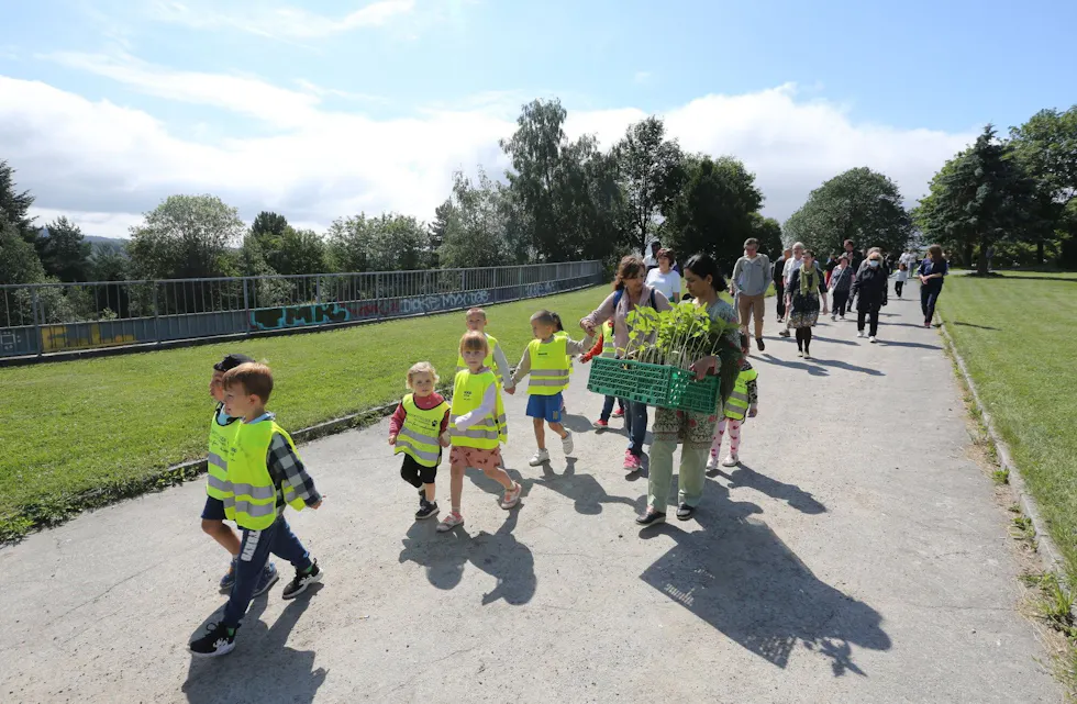 Det var mange spente barn som gledet seg stort til å kunne plante solsikkene de hadde med seg fra Regnbuen barnehage. De ledet an «prosesjonen» inn til den nye nærmiljøhagen ved Østre Aker menighet på Ulven. Foto: