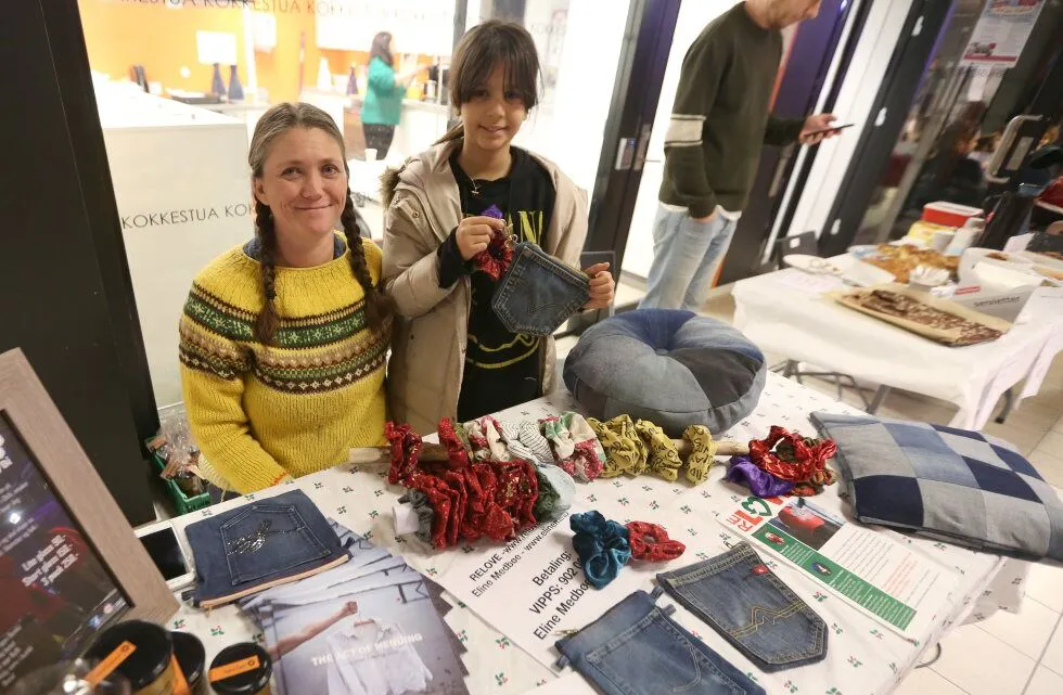 SMART GJENBRUKSLØSNING: Chamia (11) var blant de mange som lagde små fine vesker av gamle jeanslommer, godt hjulpet av Elinn Medbøe fra RELOVE. Foto: