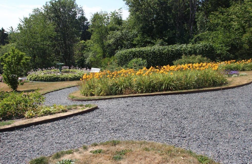 NYDELIG: I hagen finnes store uteområder med både blomster, benker og lysthus. Foto: