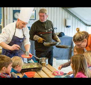 DET SERVERES: Her er Per Ivar Berget (i kokkeklær) og Arne Brimi i ferd med å servere nylaget mat til matglade barn. Foto: